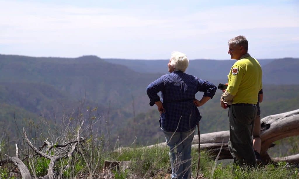 Two people admire a mountain view in Guula Ngurra National Park