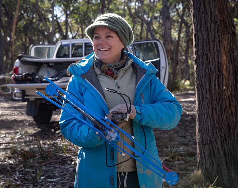 Dr Kellie Leigh in the forest with a tracker looking for koalas