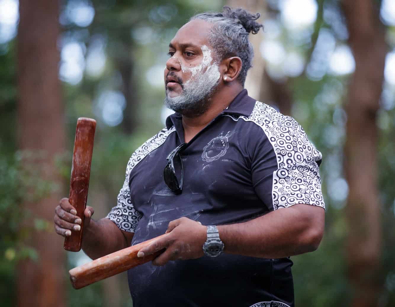 Aboriginal man in paint performs cultural customs