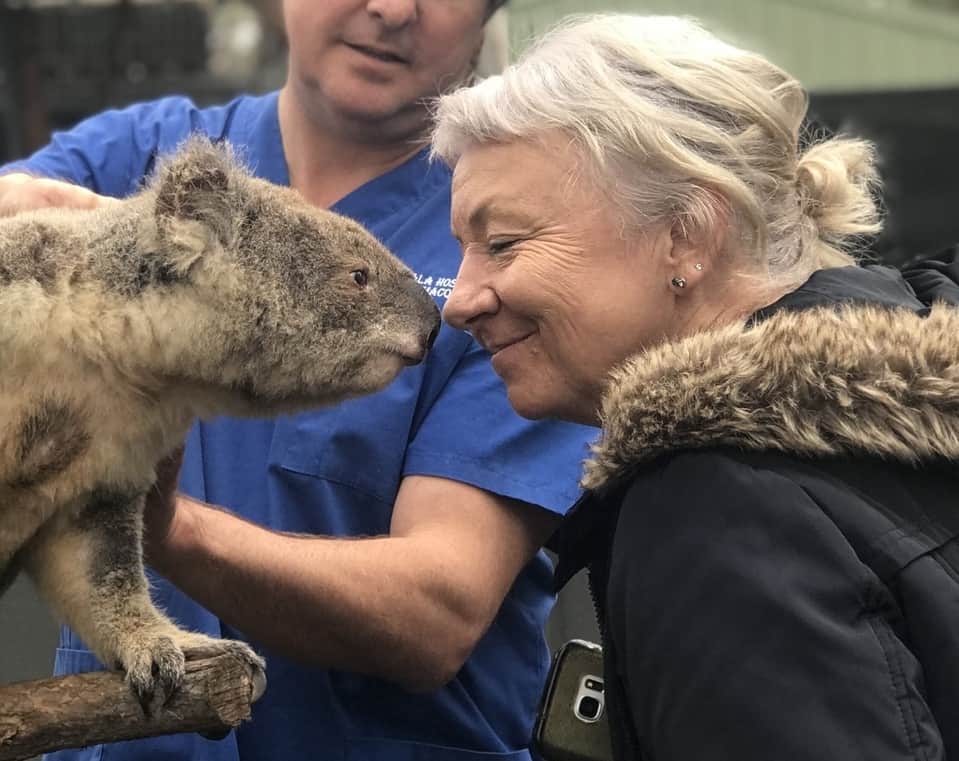 Linda Sparrow, President of Bangalow Koalas, smiles and touches noses with a koala