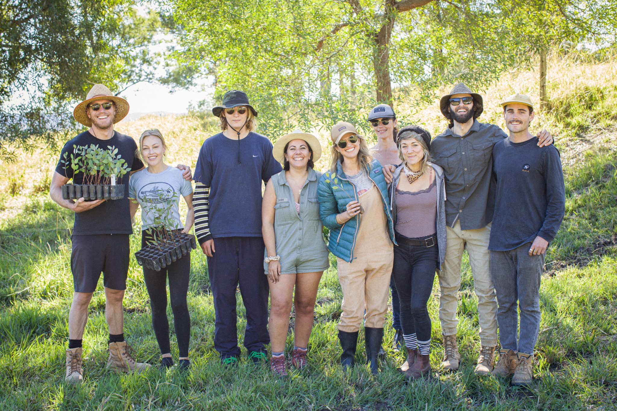 A group of people standing together and smiling on a koala tree planting day